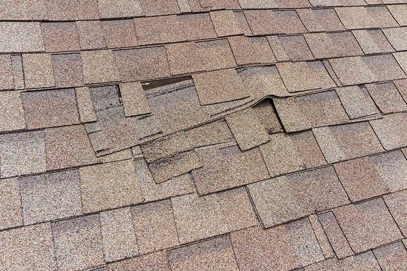 Damaged roof shingles discovered while performing home inspection services 