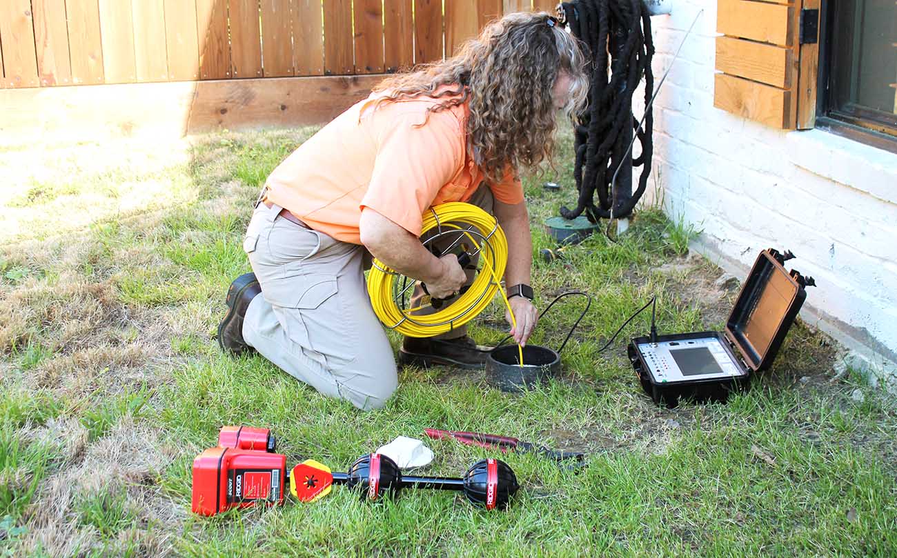 Home Inspector Michelle Door using a sewer scope